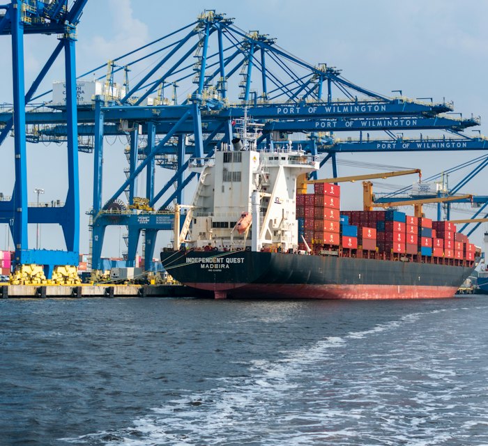 Container ship at a port beside cargo cranes