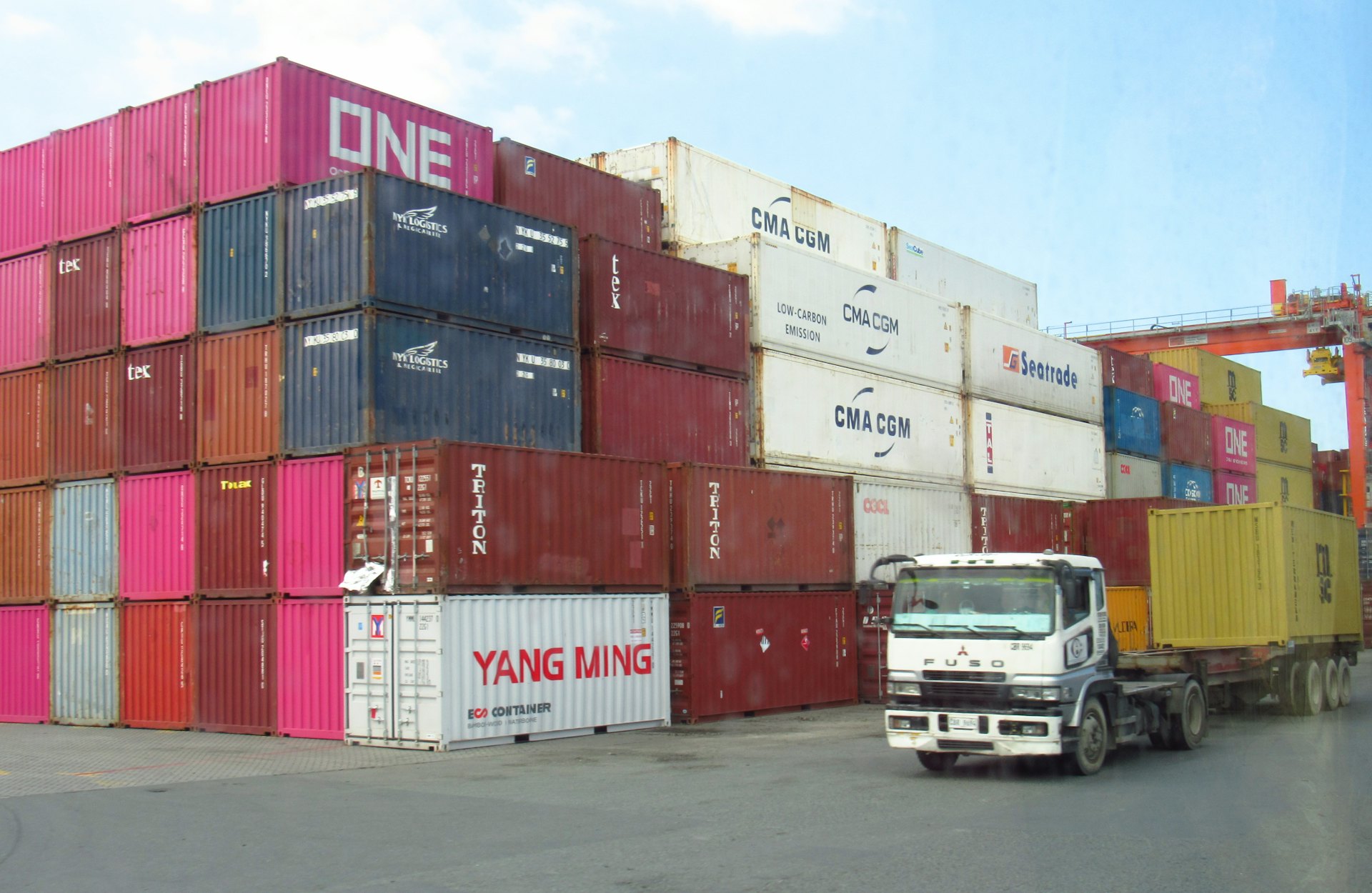 Truck moving between stacked shipping containers