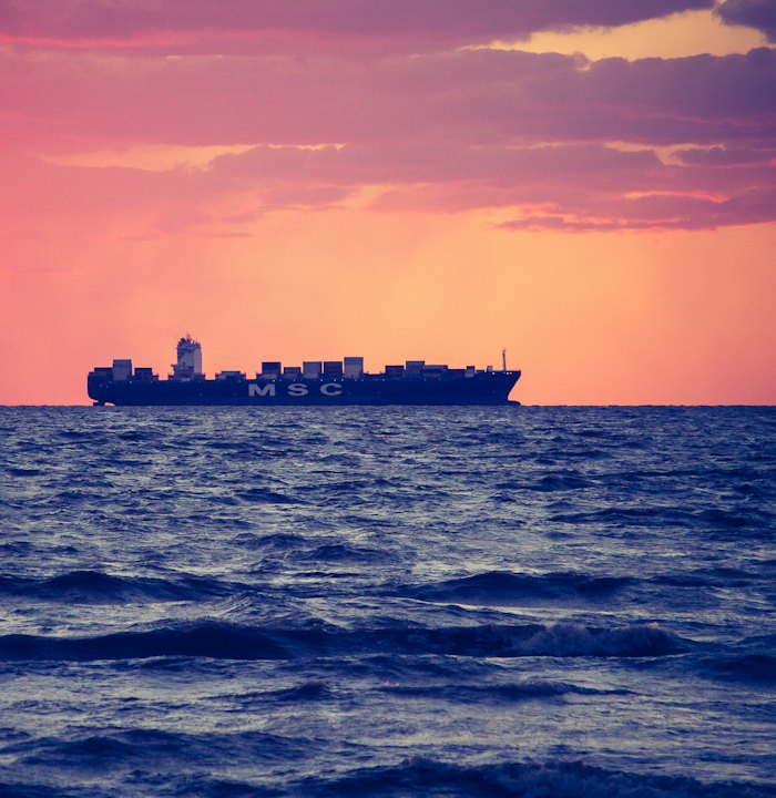 Cargo ship on the horizon at sunset