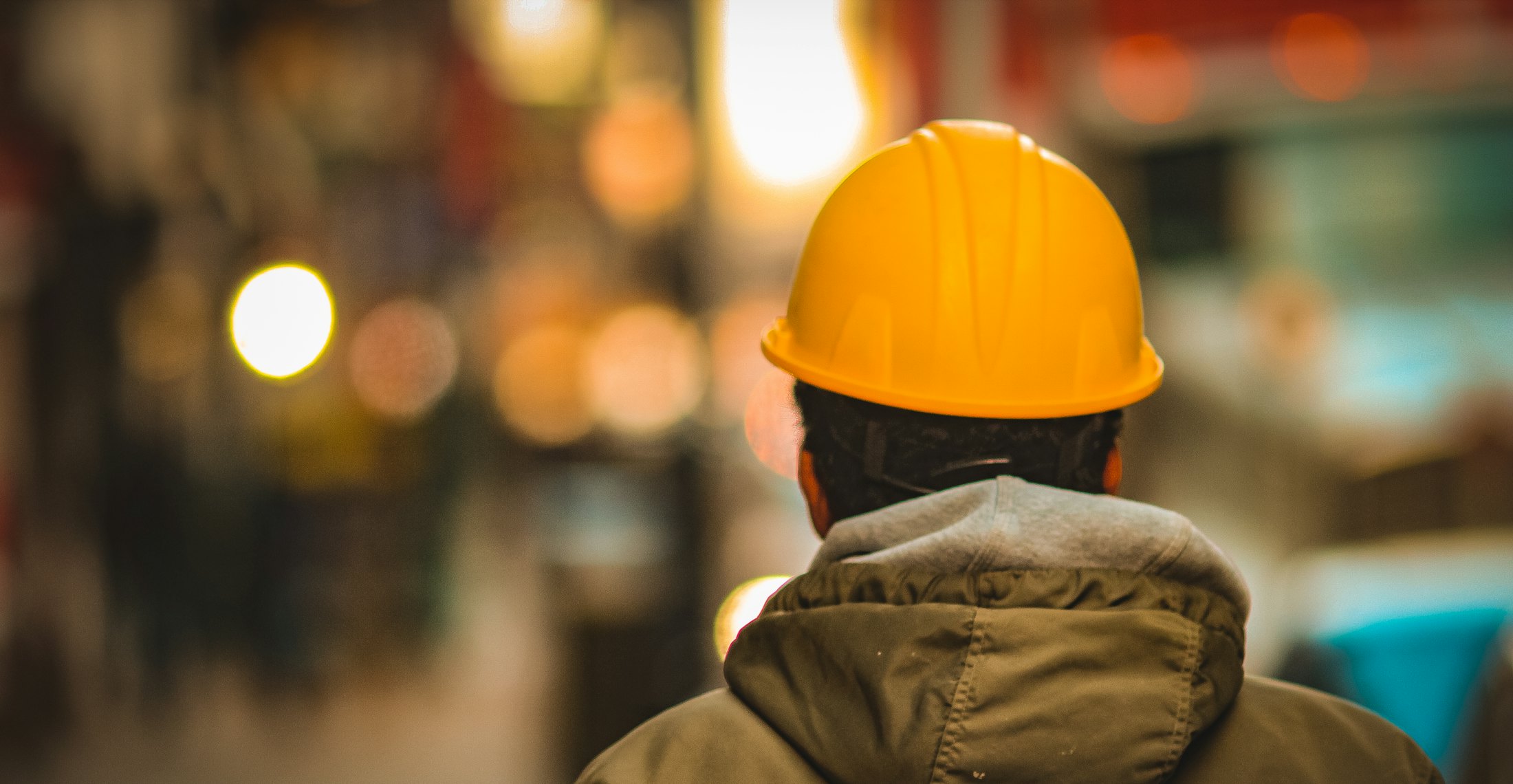 Logistics worker in a yellow hard hat inside a warehouse